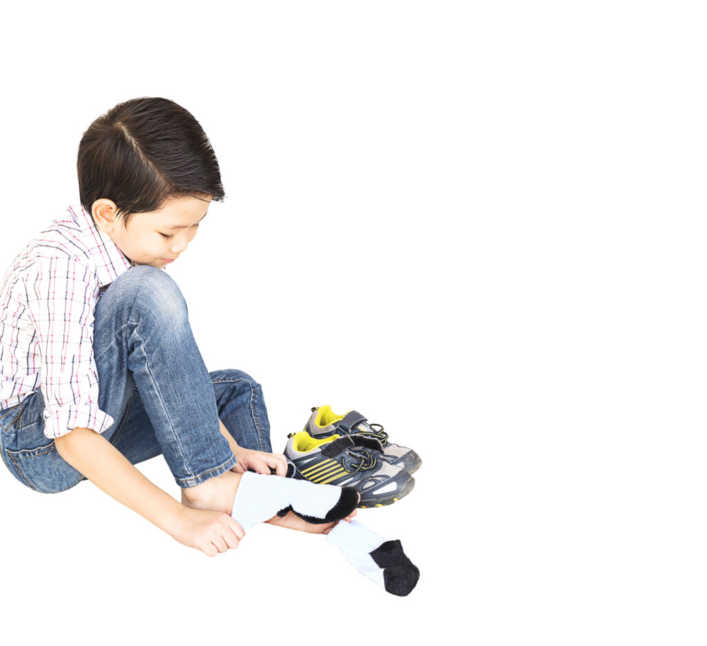 autistic child putting on adaptive shoes